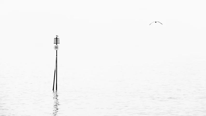 a pole sitting in the middle of the ocean surrounded by fog