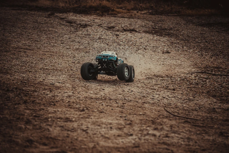 a blue toy truck in the middle of the dirt