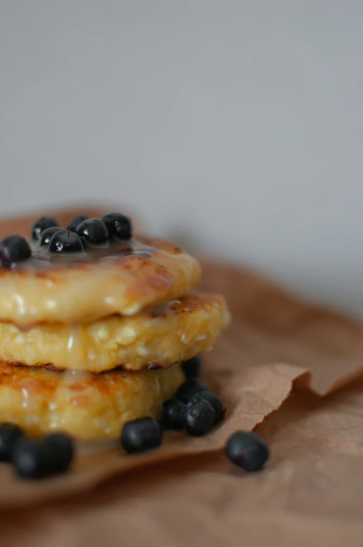 some blueberries are sitting on top of a stack of pancakes