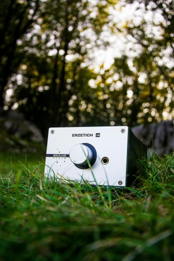 a small radio on some grass in the woods