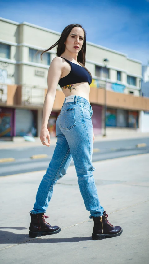 a woman in ripped jeans standing on the street