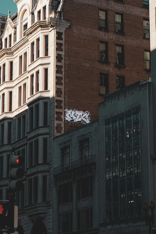 an old building with graffiti is reflected in the city's tall buildings