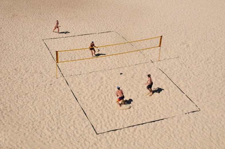 several people are on the beach playing volleyball