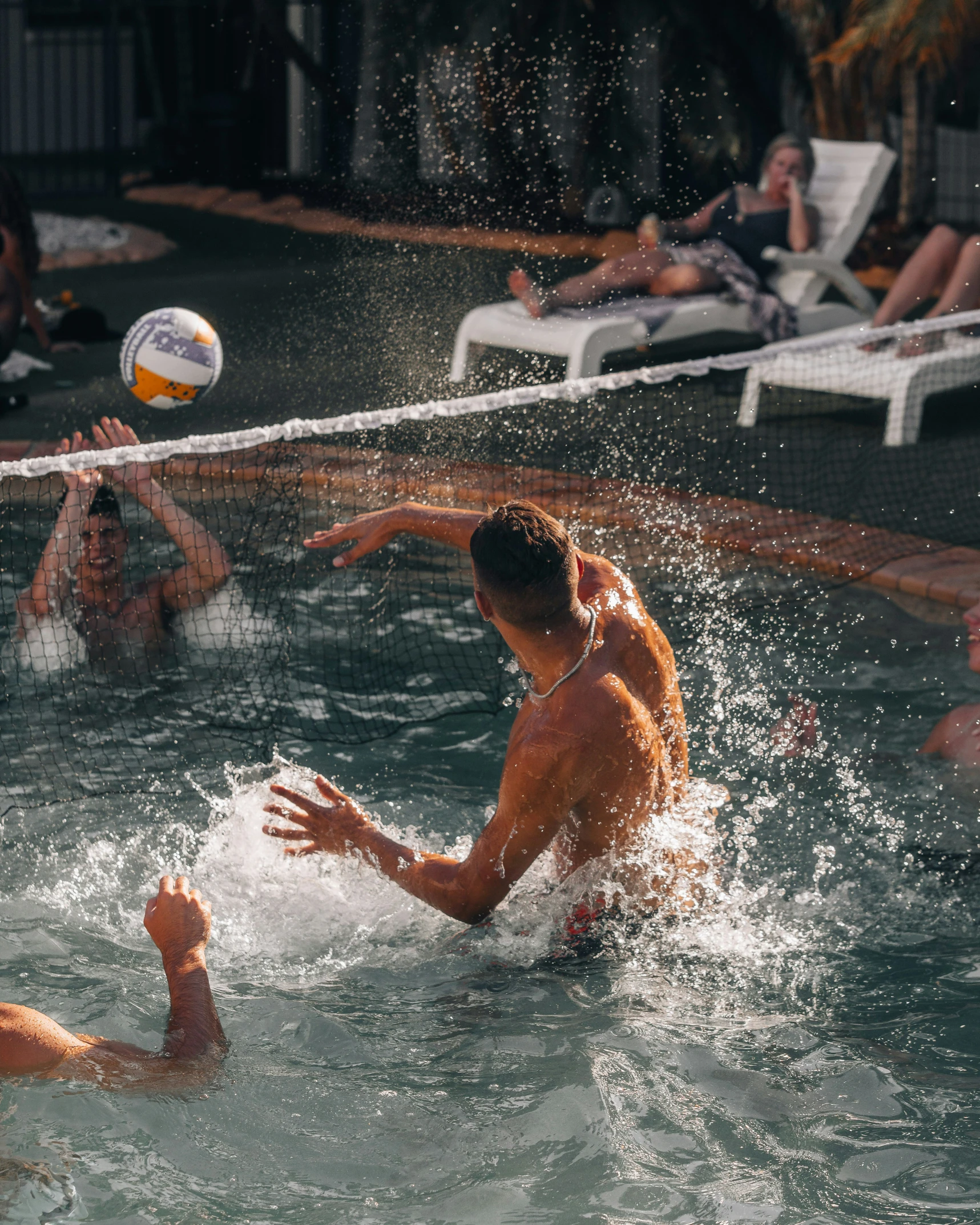 three people in the water playing with a ball