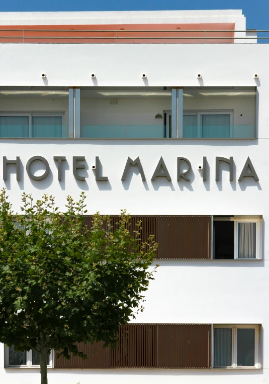 a sign that says el marina in front of a tree