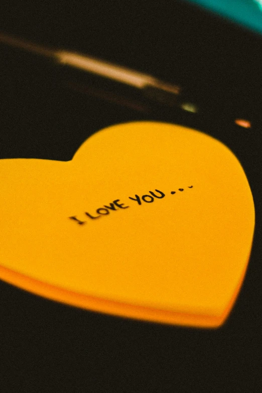 i love you text on yellow heart with black writing