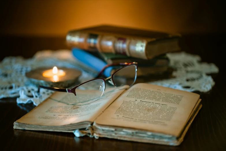 a pile of books with glasses on top of it