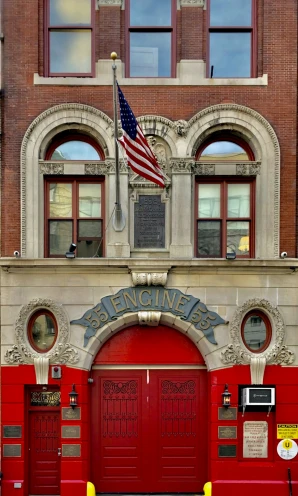 a red fire house with an american flag on top