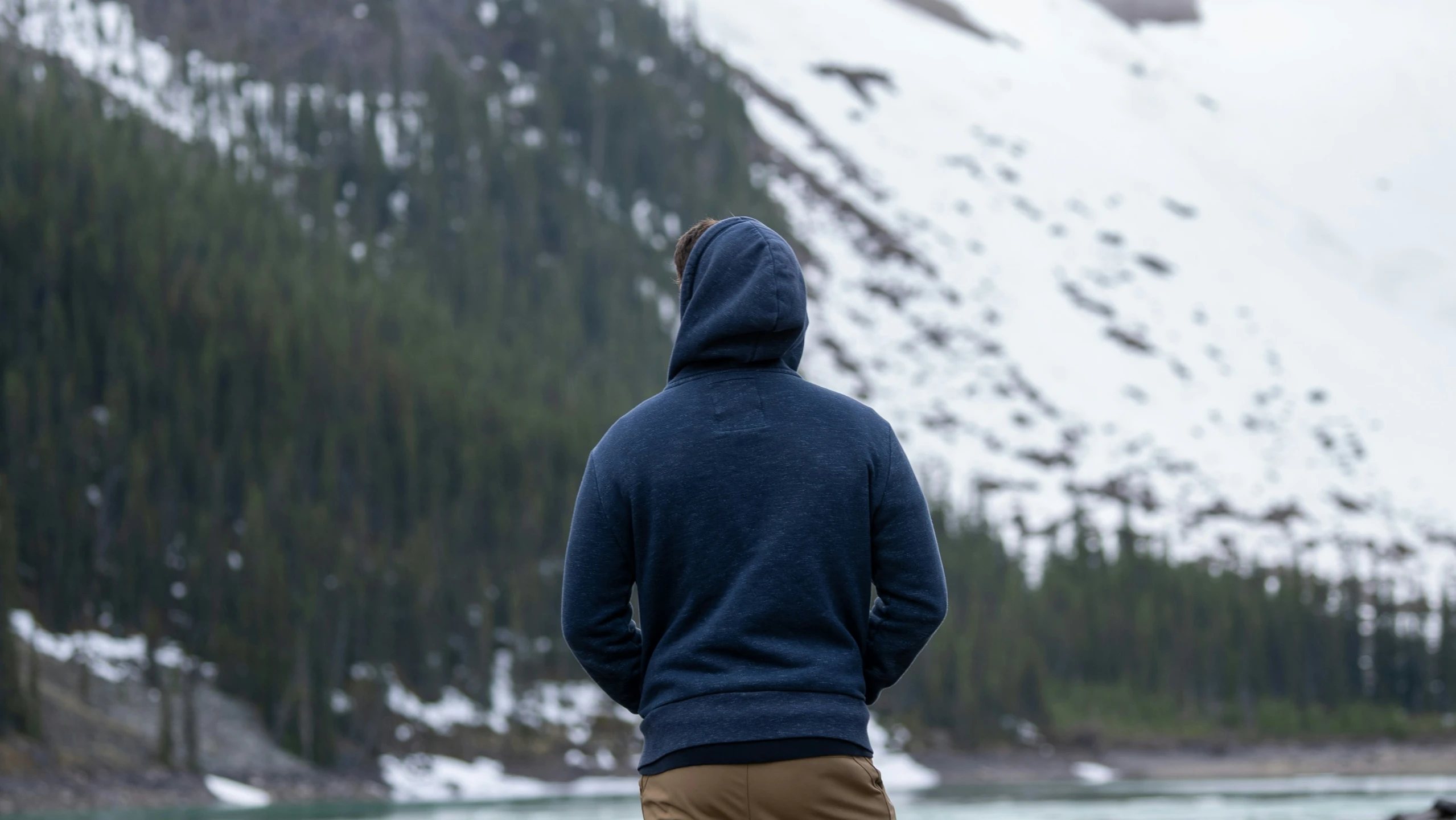 the man in the hood is looking at the mountains