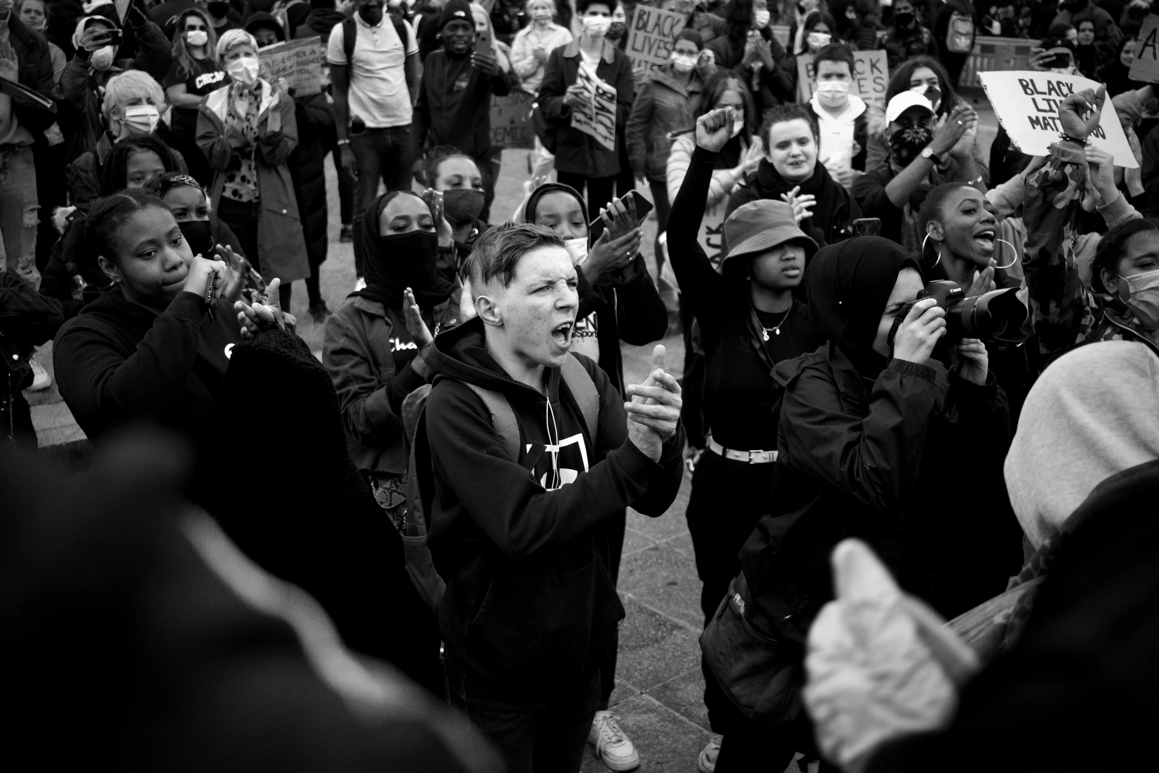 people walking with signs and shouting at someone on the phone