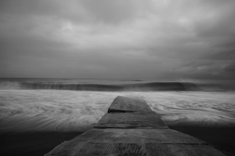 the pier is surrounded by large waves in the distance