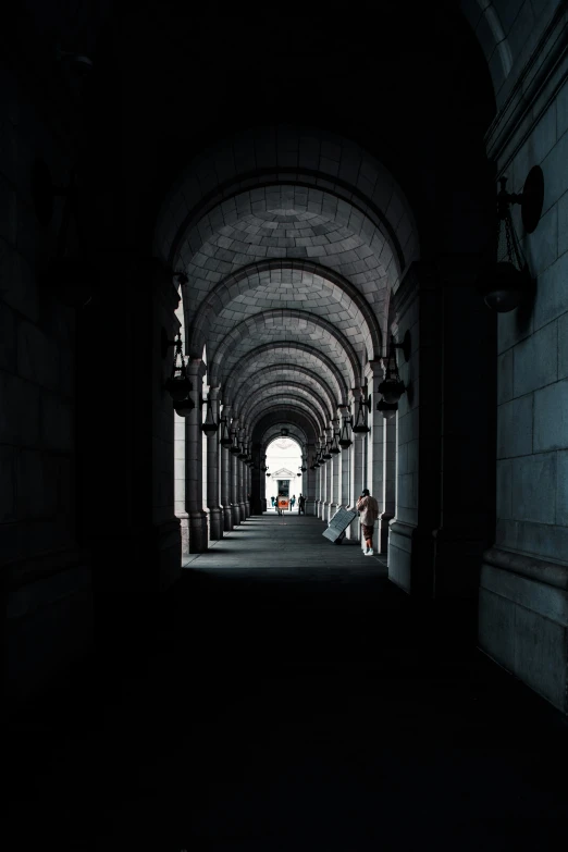 a tunnel with light on at end of walkway