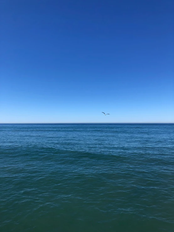 an airplane is flying in the sky over the water