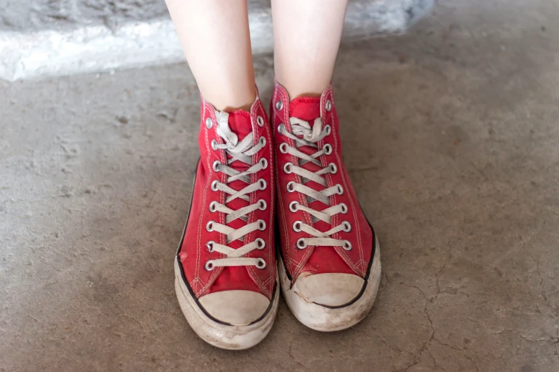 the legs of an asian woman in converse sneakers