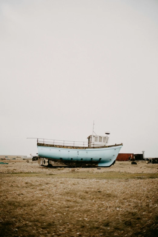 an old boat sitting on the sand