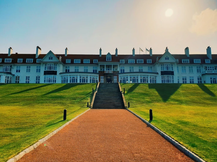 long driveway to the mansion in front of an expansive lawn