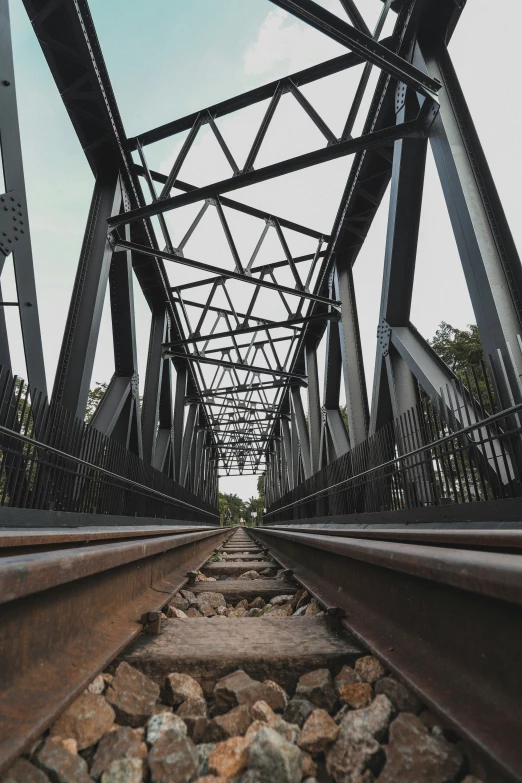 a railroad bridge is seen from the bottom