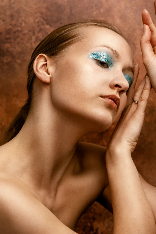 a woman wearing bright blue make up posing