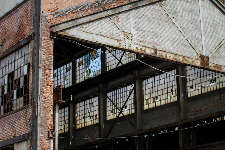 the side of an abandoned factory building that is rusting