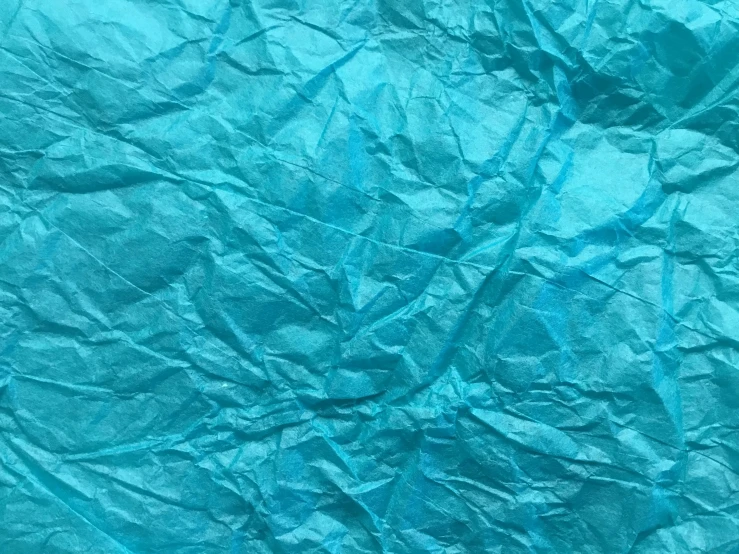 the texture of a blue sheet is being cut