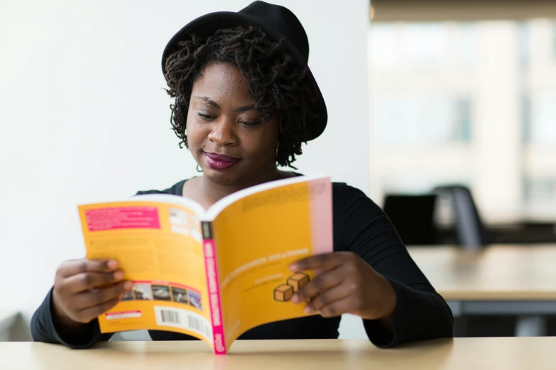 woman reading an open book in an office setting