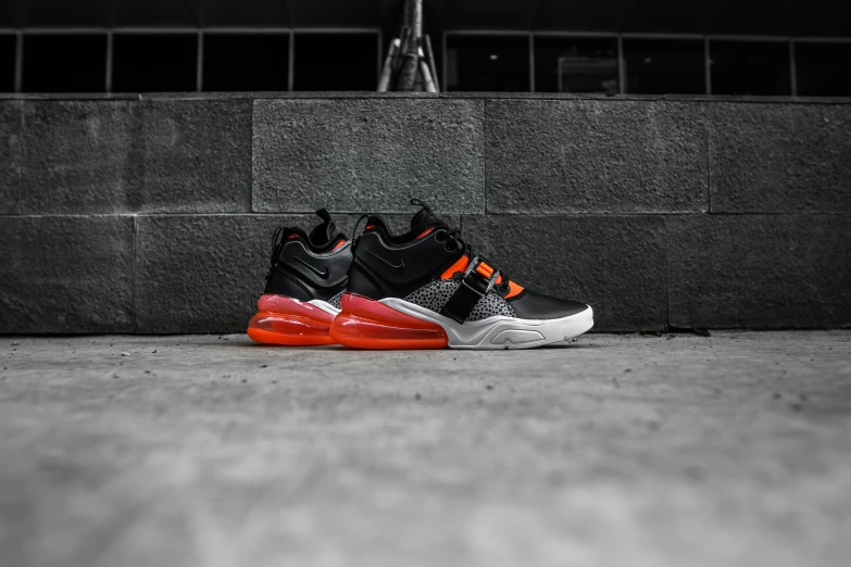 black and orange sneakers sitting on concrete steps