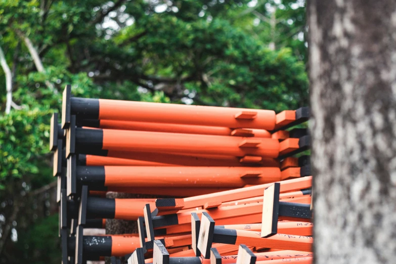 a bunch of orange and black sticks that are stacked high