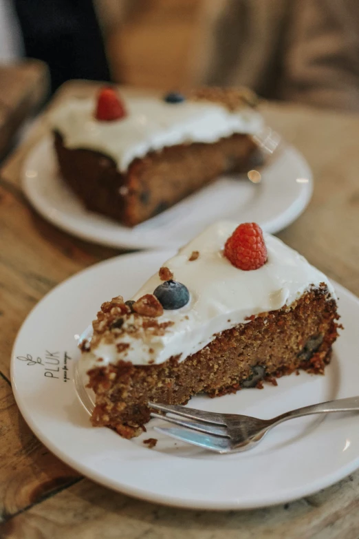 a piece of carrot cake on a plate with whipped cream