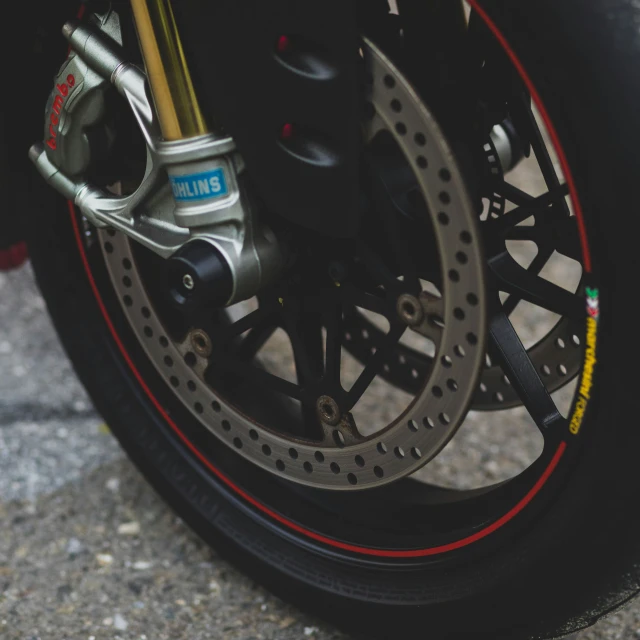 a black motorcycle wheel and kes, with a blue sky background