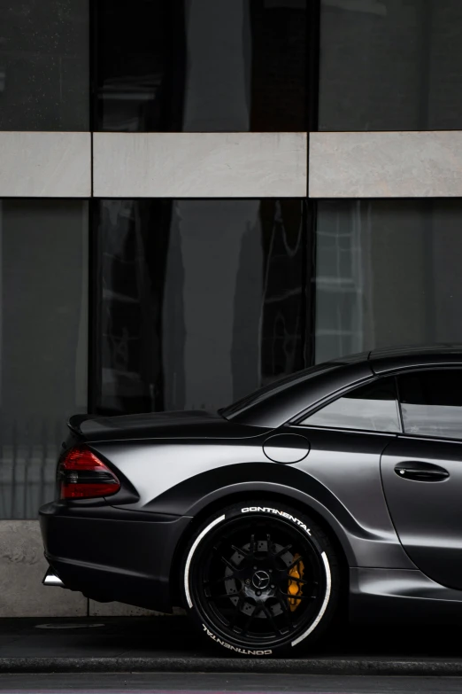 a black sports car parked next to a tall building