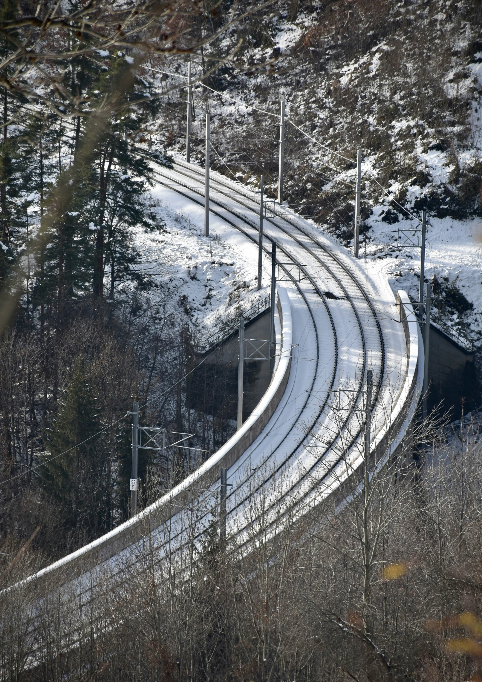 a curved train track is covered in snow