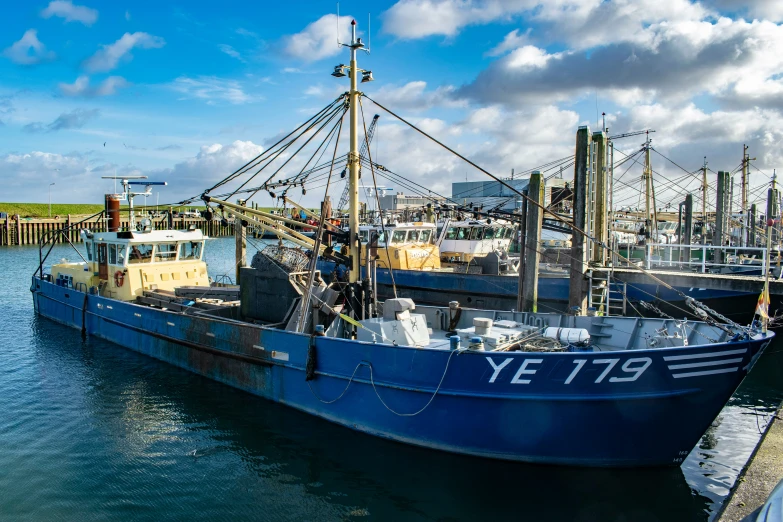 a large blue boat docked next to other boats