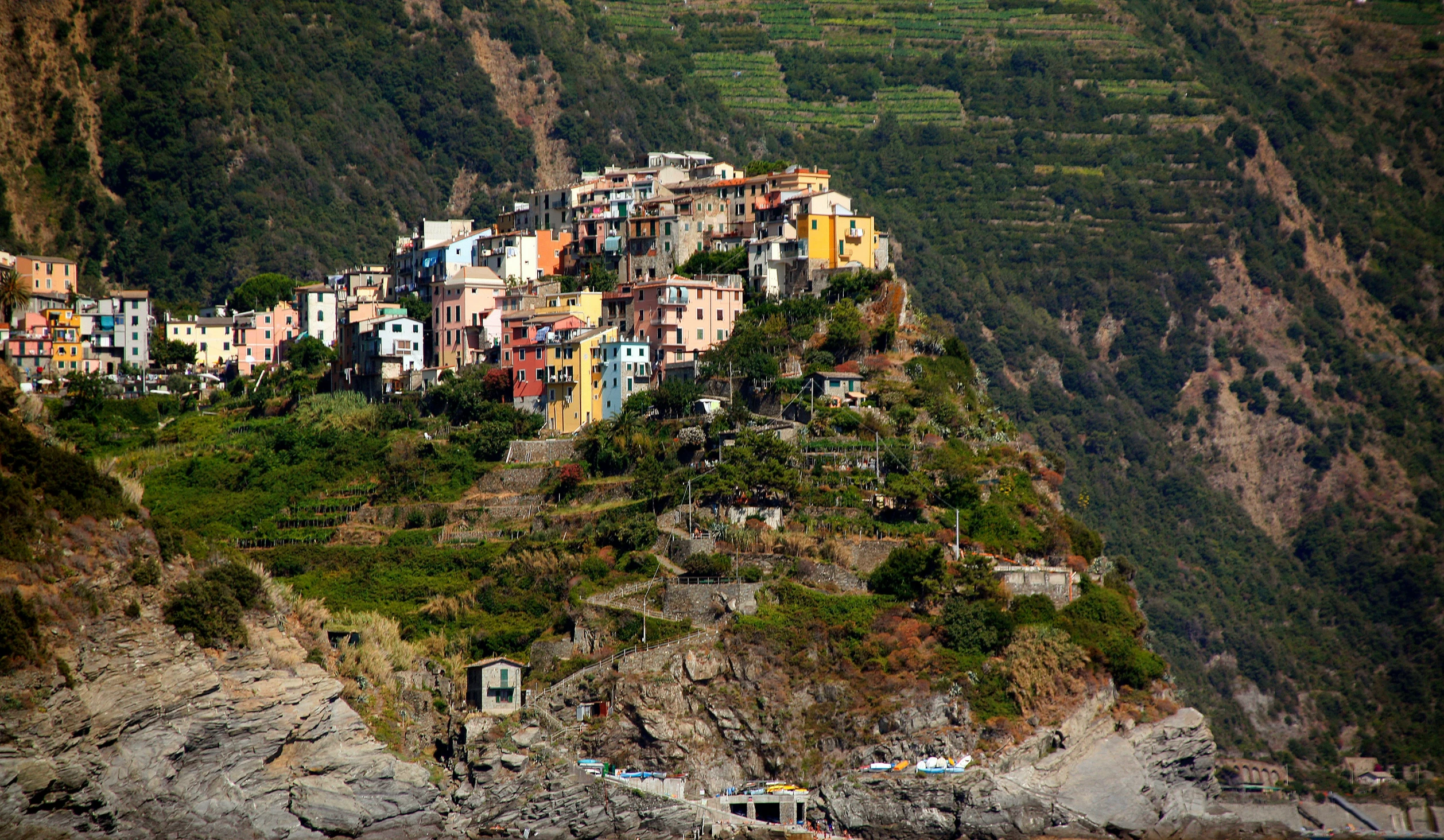 a village on the edge of a hill surrounded by trees