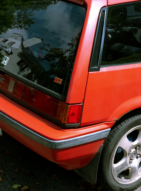 an orange honda is parked by itself on the street