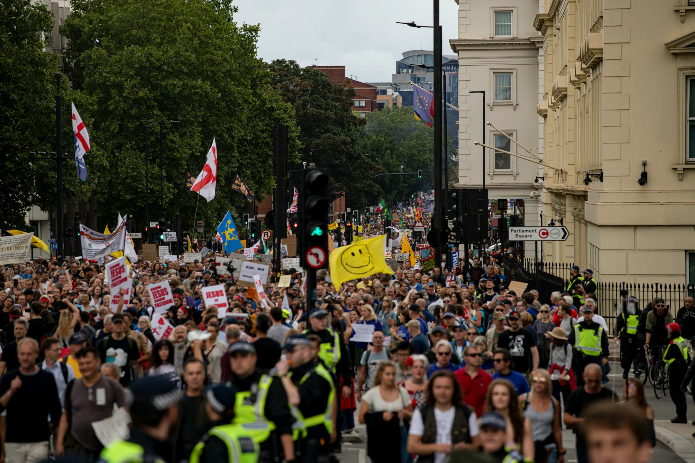 many people walking down the street in a protest