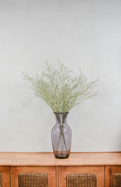 a vase with some small grass plants in it