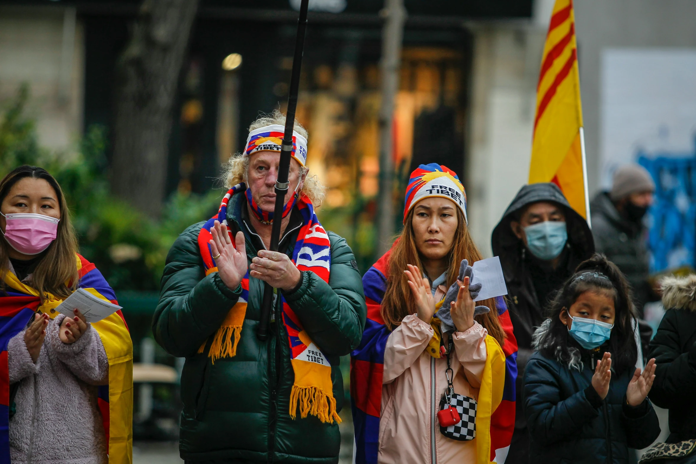 a group of people wearing face masks and some with flags