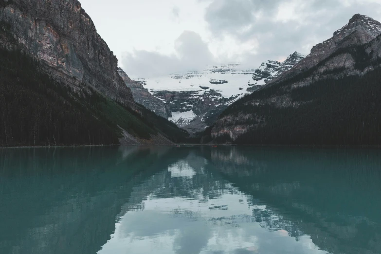 a small body of water with mountains in the background