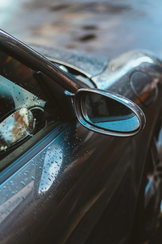 a car has its window open while sitting in the rain