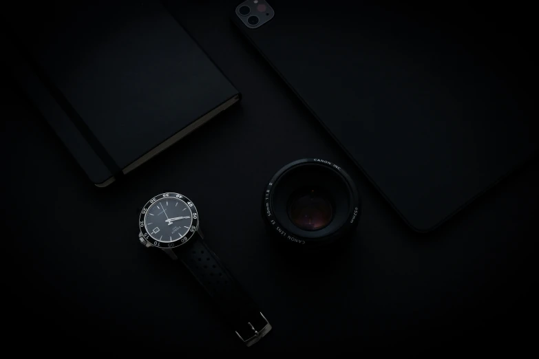 a watch and a pen next to a camera