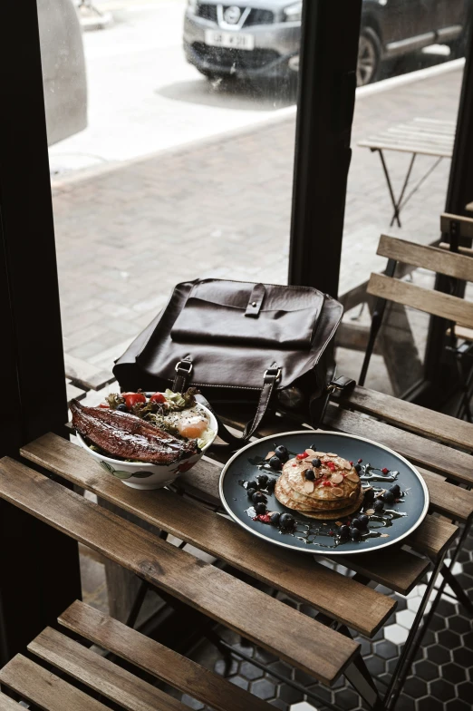 an outdoor wooden table holding a plate of food