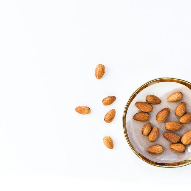 almonds on a white plate, with a few scattered pieces