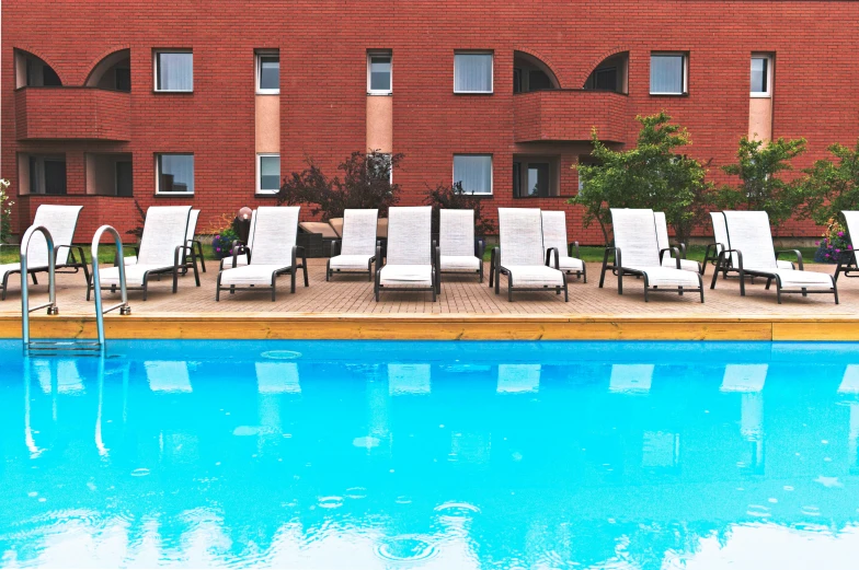 a el swimming pool with lounge chairs set in front