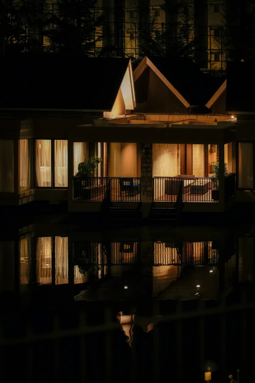 an apartment is reflected in the water at night