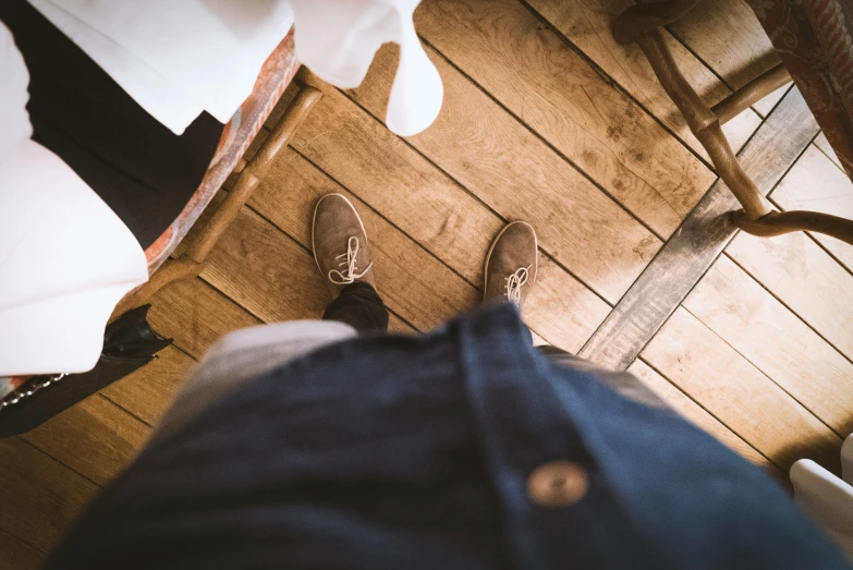 a person wearing blue jeans with some brown shoes