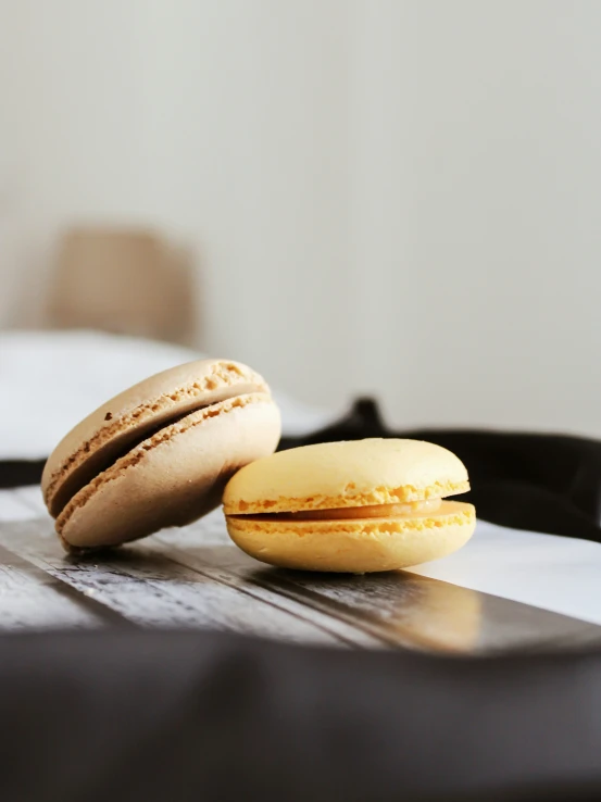 two macaroons are on a table next to a cell phone