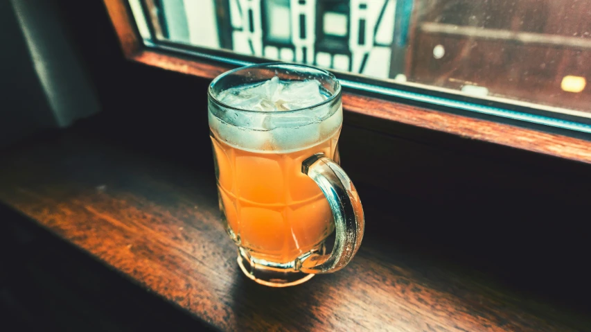 a tall mug sits on the counter next to a window