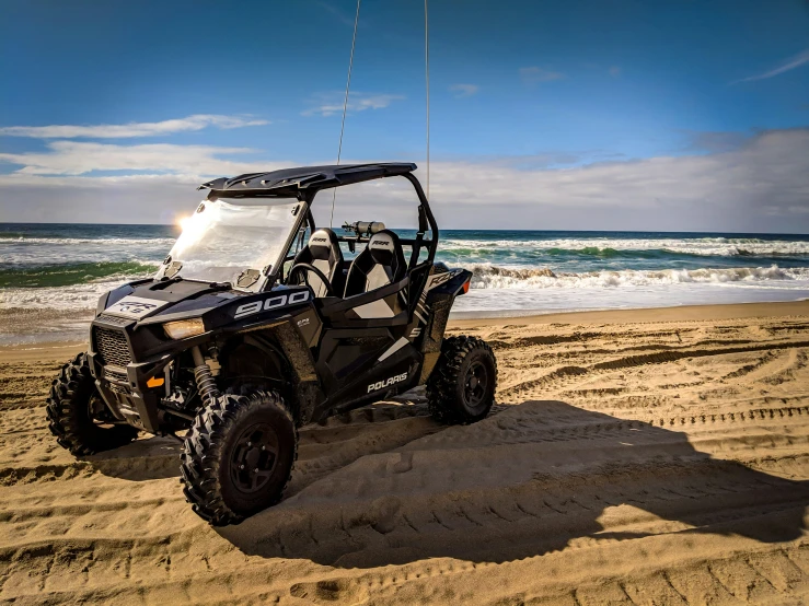 a polargear dune buggy on the beach near the ocean