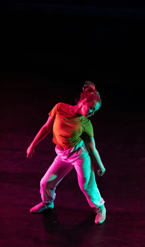 man with skateboard standing on pavement in illuminated room