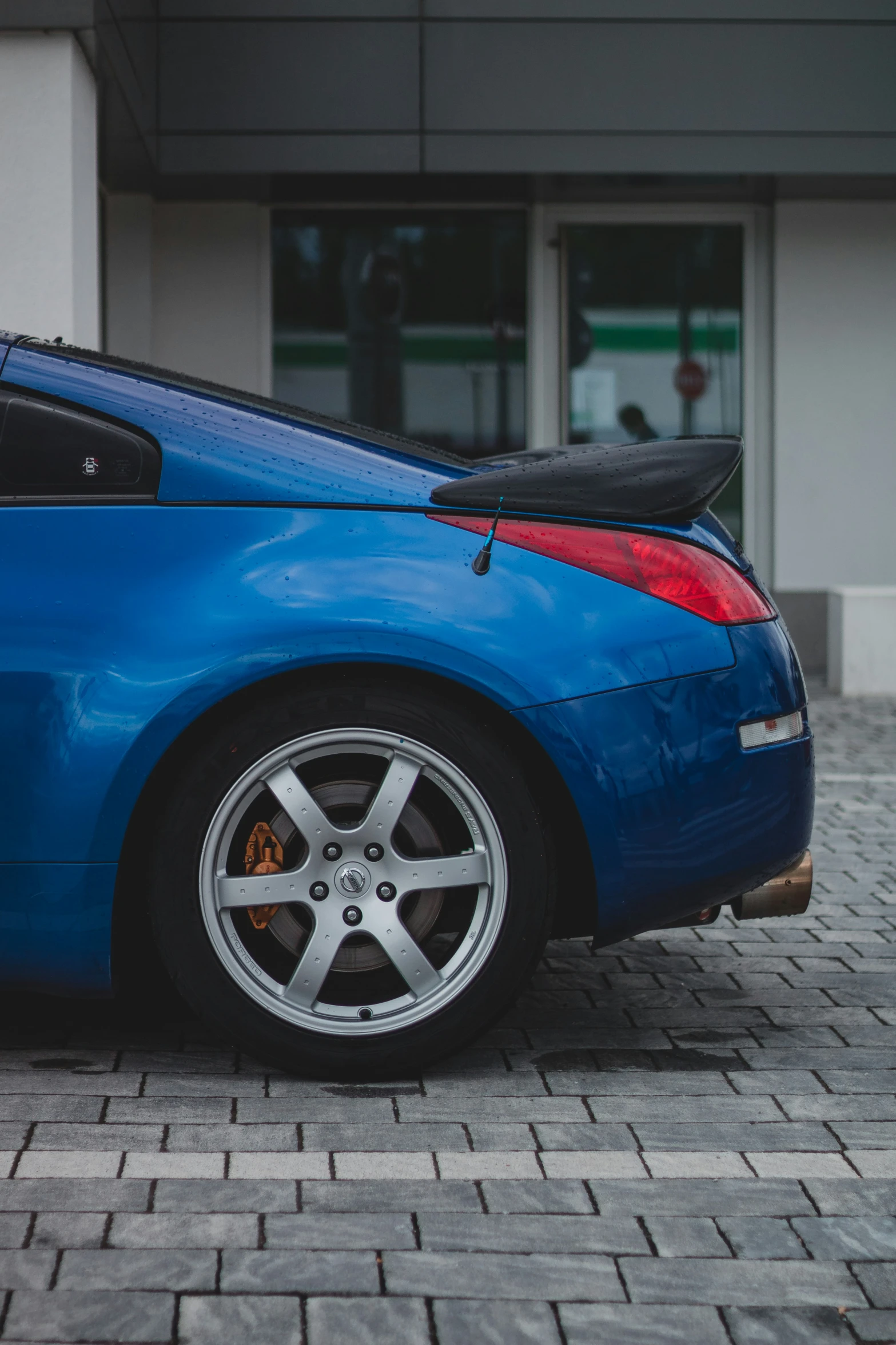 the side view of a blue sports car parked outside